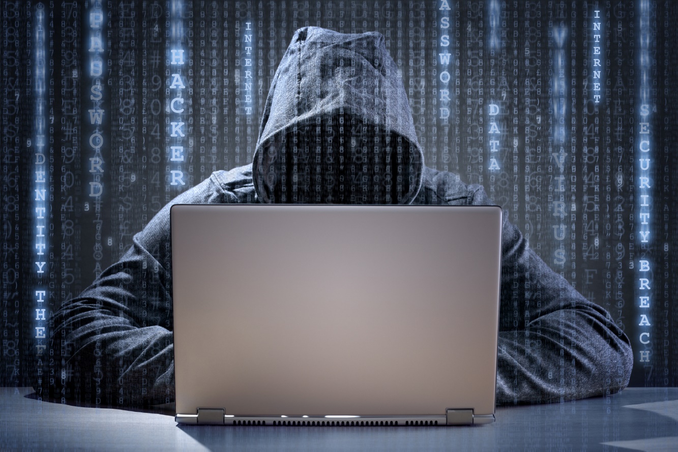 hooded man hacking laptop